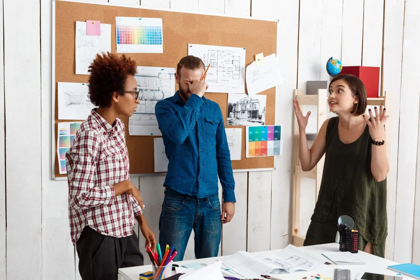 Коллеги спорят, обсуждают эскизы и новые идеи в офисе.