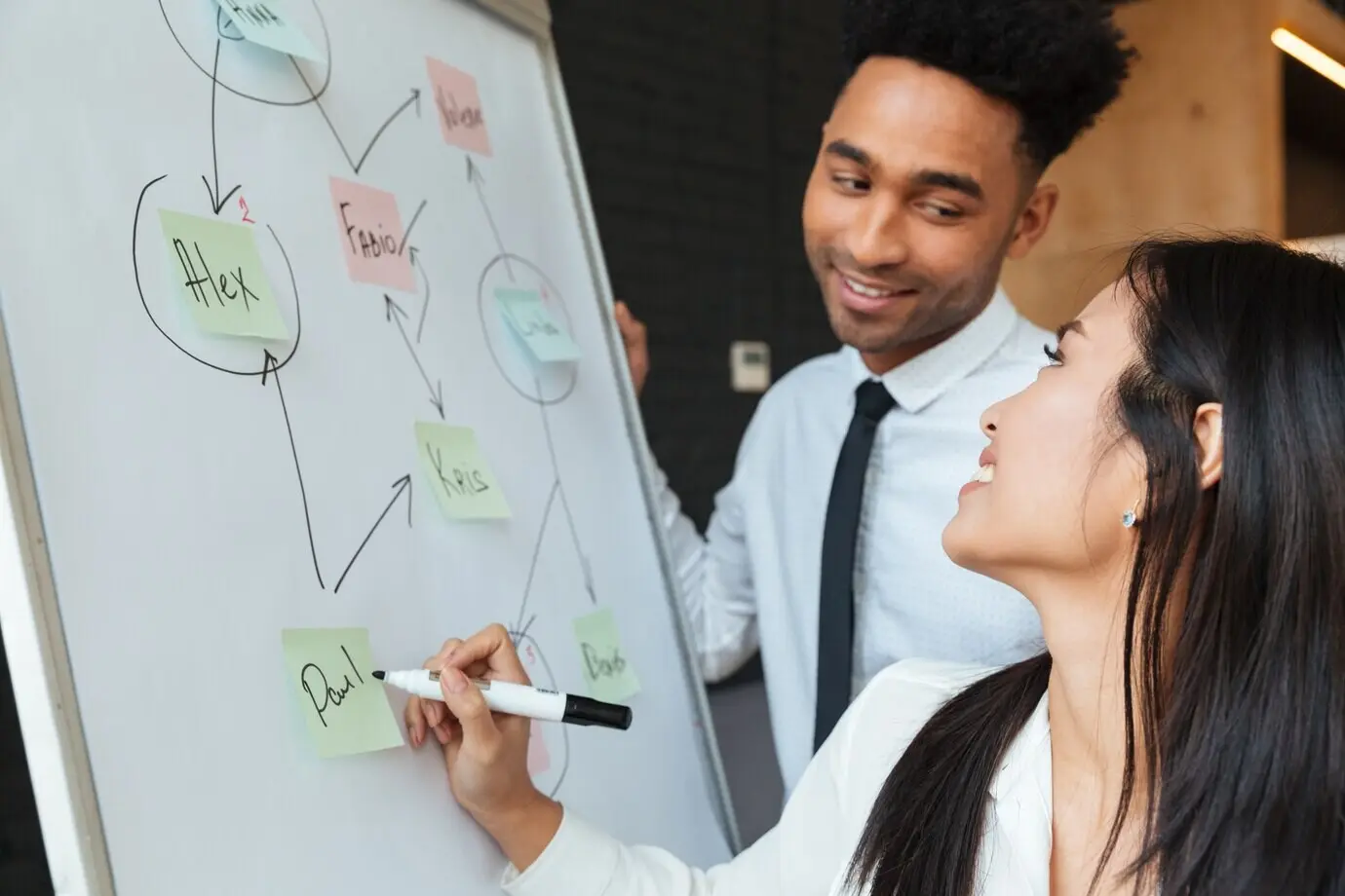 Радостные молодые коллеги что-то пишут.