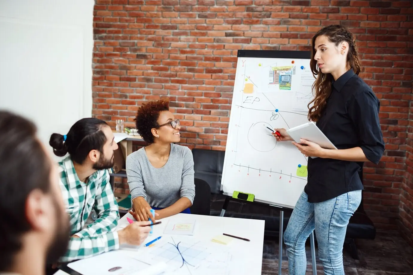 Девушка проводит презентацию для коллег на деловой встрече.